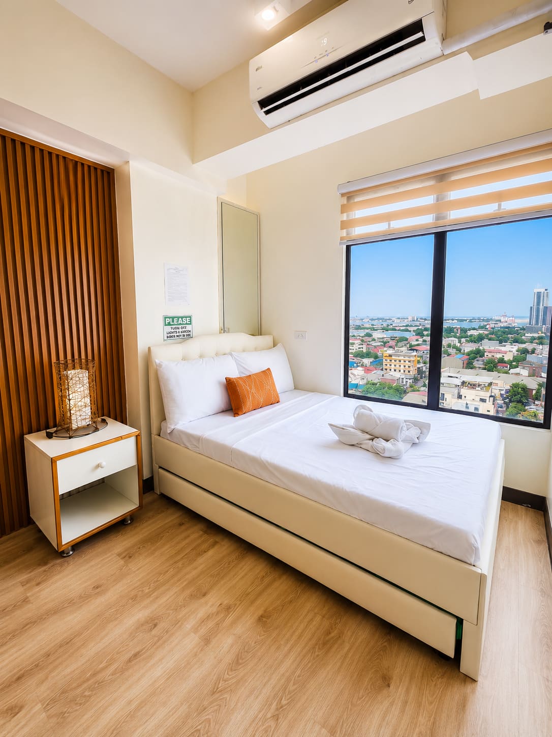 Double bed with a pull-out double trundle beside a window overlooking Cebu harbor