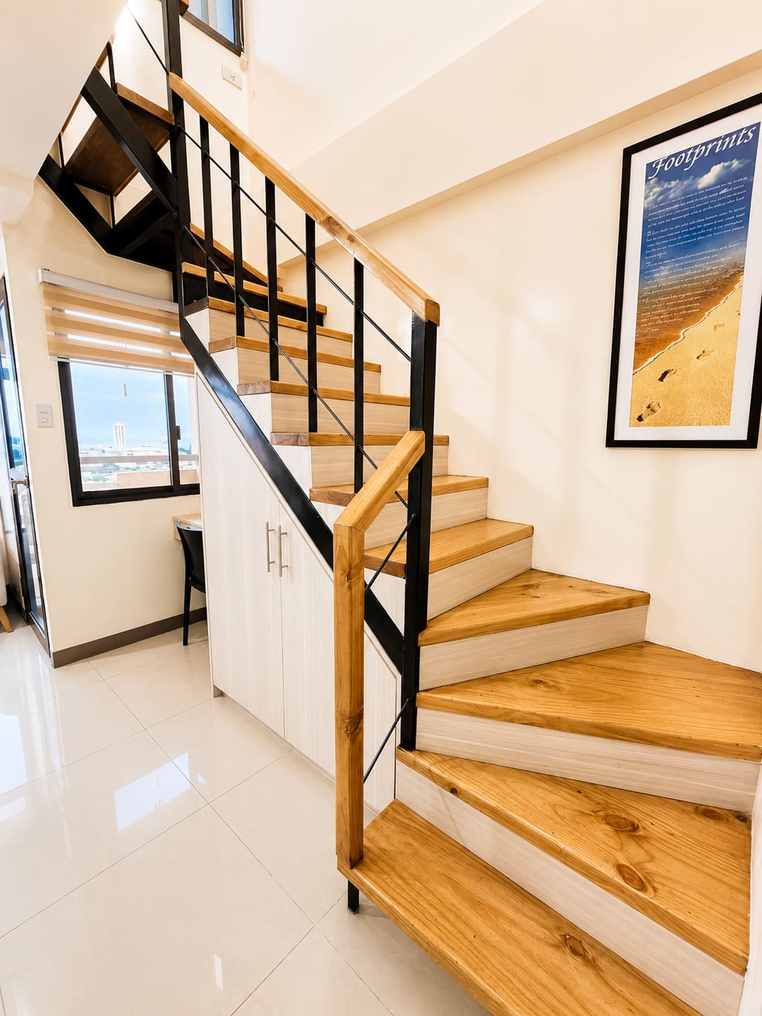 Wooden staircase up to the loft, with a framed Footprints poem on the wall